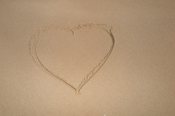 Fototapeta na wymiar Beautiful heart shape drawn in the sand