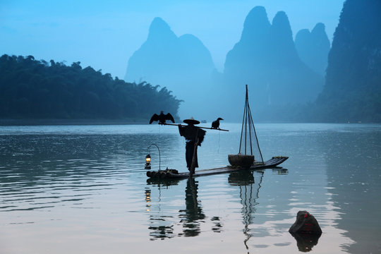Chinese man fishing with cormorants birds in