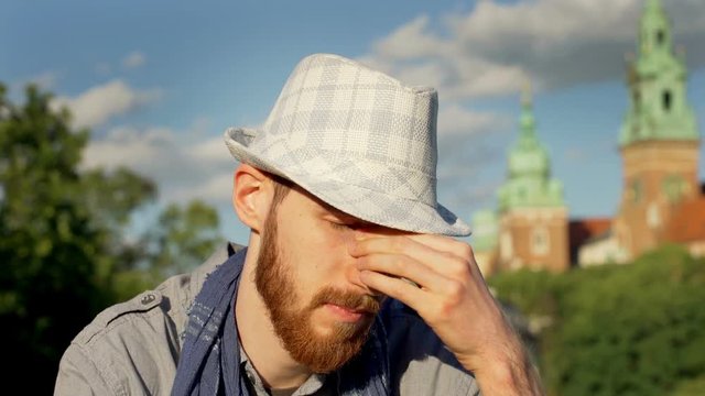 Man looking worried while sitting at sunny dat outside
