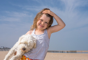 belle jeune fille jouant avec son chien sur la plage