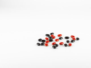 red and black Vitamin Pills isolated on white background.

