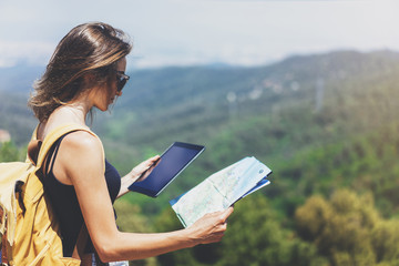 Hipster young girl with backpack enjoying panoramic mountain sea, using map and looking at horizon. Tourist traveler texting on tablet computer on background landscape Barcelona view mockup