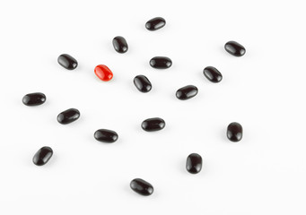red and black Vitamin Pills isolated on white background. focus point selection is red.

