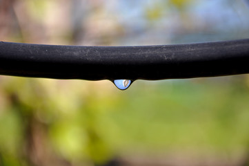 .Drip Irrigation System Close Up. prepared for planting in early Spring. prepared for planting in early Spring. A drop of water on a black hose. Reflection in a drop.