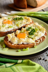 Fried bread slices with eggs, cheese and green onion