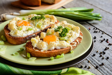 Fried bread slices with eggs, cheese and green onion