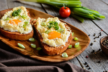 Fried bread slices with eggs, cheese and green onion