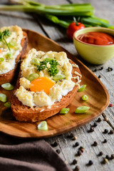 Fried bread slices with eggs, cheese and green onion