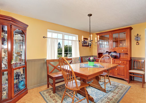 Traditional dining area with wooden furniture and rug.