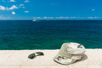 The cap and glasses on a background of the sea