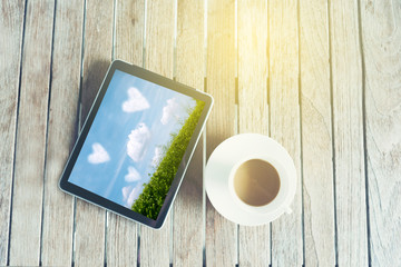 Black tablet ipad on table desk with coffee cup