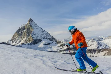 Fotobehang Ski touring man reaching the top in Swiss Alps. Matterhorn in th © Gorilla