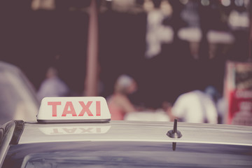 Close up of car roof taxi sign on the street during the day.