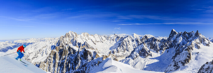 Skier skiing downhill Valle Blanche in french Alps in fresh powder snow. Snow mountain range Mont...