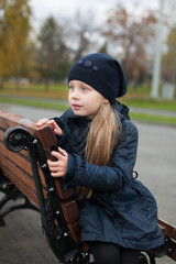 girl sitting on a bench waiting for autumn day