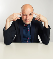 funny bald businessman trying to think seriously