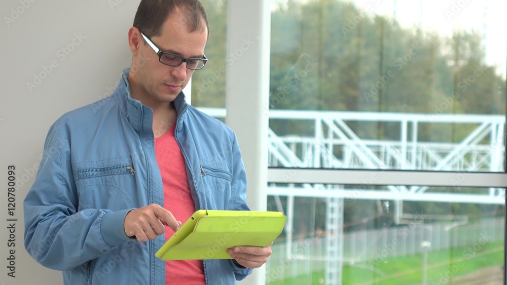 Aufkleber programmer in glasses using his tablet computer at modern railroad station