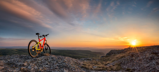 Fototapeta na wymiar Sunset from the top / Beautiful sunset view with a mountain bike at the top of a hill