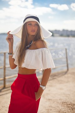 beautiful girl in a white blouse and red skirt and white hat