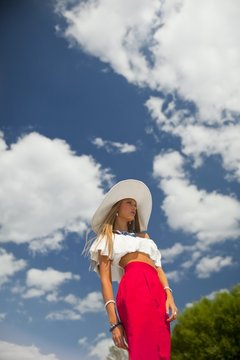 beautiful girl in a white blouse and red skirt and white hat