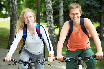 Naklejka premium Young couple riding bicycle outdoors