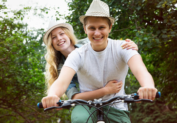 Obraz premium Young couple riding bicycle outdoors