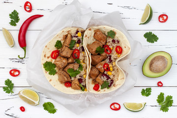 Mexican tacos with quinoa salad, meat, black beans and corn on rustic wooden table. Recipe for Cinco de Mayo party. Top view.