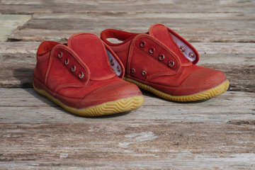 Old brown sneakers , Students sneakers on wooden background