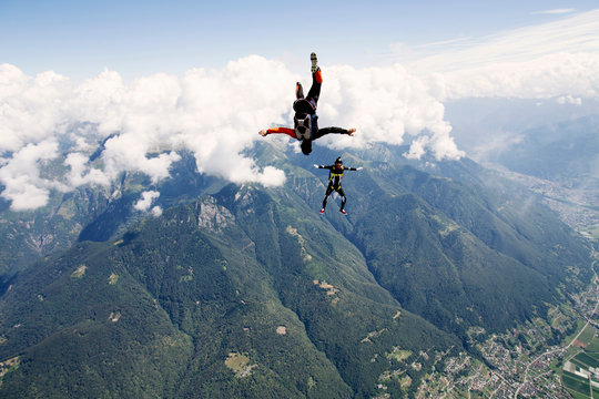 Parachute jumpers falling dawn in clouds
