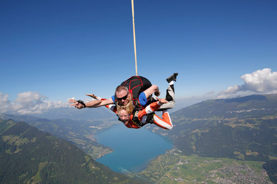 Tandem sky divers free falling as parachute released, Interlaken, Berne, Switzerland