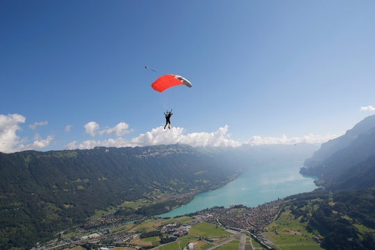 Male sky diver with parachute over lake, Interlaken, Berne, Switzerland