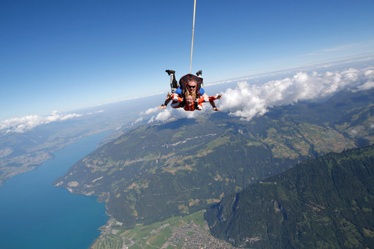 Tandem sky divers free falling as parachute released, Interlaken, Berne, Switzerland