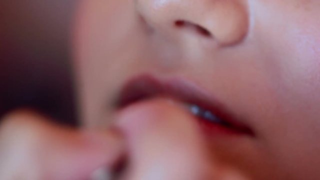 makeup artist puts a lipstick on female lips