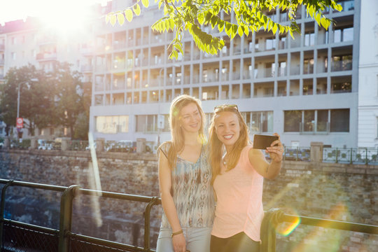 Two adult female friends taking smartphone selfie in city, Vienna, Austria