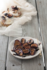 Roasted ricotta drizzled with balsamic vinegar cream. Cheesecloth and ricotta fit trifle dessert in the background. 