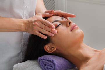 Obraz na płótnie Canvas Woman massagist make face lifting massage in spa wellness center