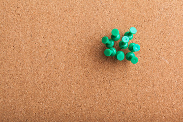 Group of thumbtacks pinned on corkboard
