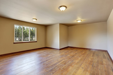 Empty room interior with creamy tone walls and hardwood floor