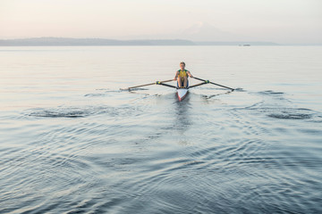 Man rowing row boat in sea around Bainbridge Island, Washington, USA