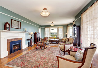 Traditional living room interior in blue and white tones, fireplace and rug