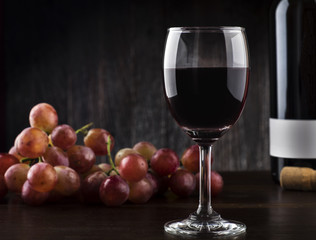 Wine glass , Bottle and Grapes on a wooden background