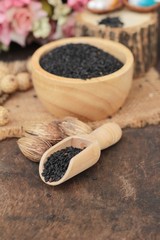 Poppy seeds of organic on wood background.