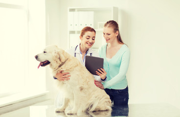 happy woman with dog and doctor at vet clinic