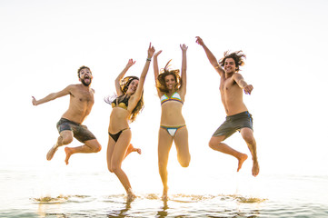 Group of friends jumping on the sea.