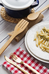 Served table with pasta and sauce in blue plate