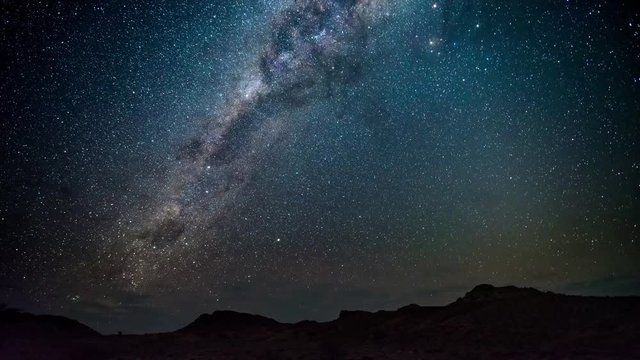 The apparent rotation of an outstandingly bright Milky Way and starry sky beyond mountain of the Namib desert, Namibia. Time Lapse 4k video.