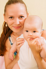 mother playing with her child. eats finger