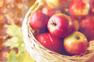 close up of basket with apples on wooden table