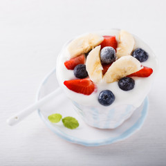 Yogurt,homemade in a ceramic bowl   with berries and mint   on a white background.Breakfast.Healthy food or diet concept.selective focus.