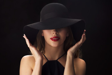 Fototapeta na wymiar beautiful woman in black hat over dark background